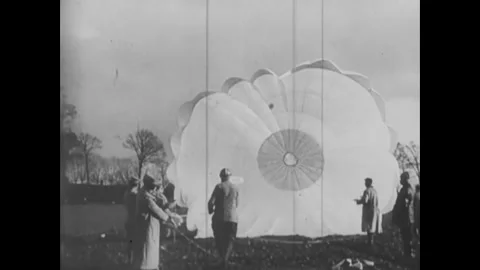 1916 - French airmen roll up a parachute after a pilot has landed with it. Stock Footage 241668053
