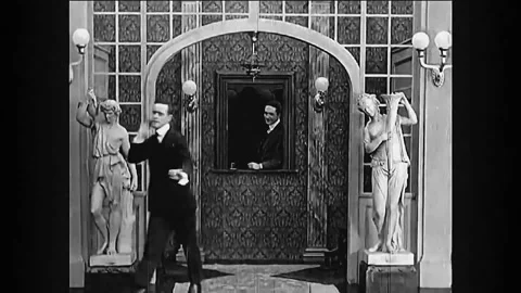 1916 - in this silent comedy, a man leaves his hat in the cloakroom and enters a Stock Footage 246359345