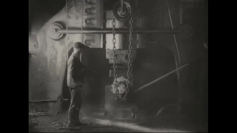 1918 - AEG Germany mortar production - Worker forging iron block Stock Footage