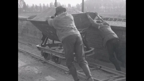 1919 - Quarry workers push a cart and a block is sawed and a bricklayer is shown Stock Footage 85959296