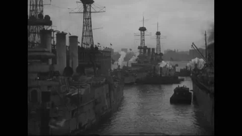 1919 - Tugs pull US Navy ships, including the USS Agamemnon, into the port of Stock Footage 234415304