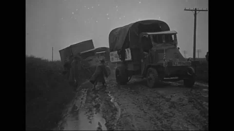 1919 - US Army vehicles try to get a truck free from a muddy road, and a tractor Vidéo 238675896