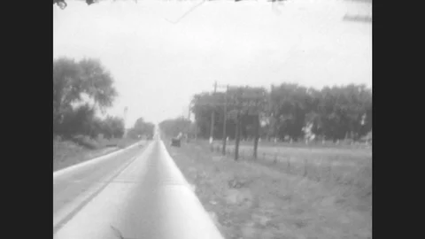 1920s: Car driving down road with power lines running parallel to it. Train Stock Footage 78931628
