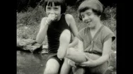 1920S: Children Sit On Ground And Talk. Girls Walk Down Slope In Woods. Man Stock Footage