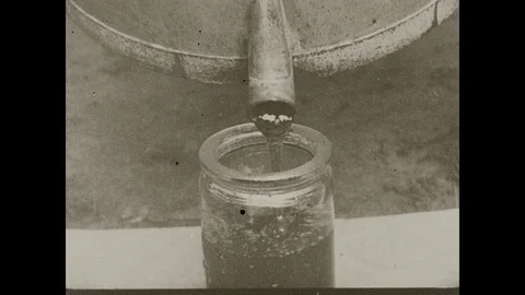 1920s: Honey pours from spout into jar. Stock Footage