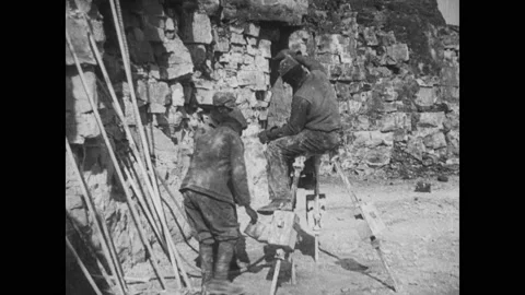 1920s: Laborers at work. Blast from hillside. Laborers work on hillside. Stock Footage 158446424