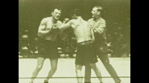 1920s: Men fight in boxing ring. Referee intervenes, man sucker punches other Stock-Footage 111552197