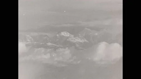 1920s: Mountain peaks through the clouds. Locals pull Europeans in carts along Video stock 232948845