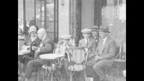 1920s: People sit at tables outside caf?. Cars driving to and away from Arc de Stock-Footage 86660088