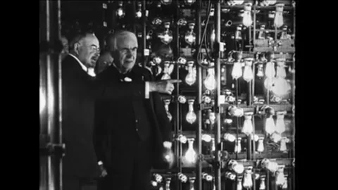 1920s - Thomas Edison shows other men an assemblage of light bulbs. Stock Footage 155855837
