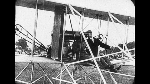 1920s: Two men sit in early Wright brothers plane. Propellers start and Stock Footage 112457037