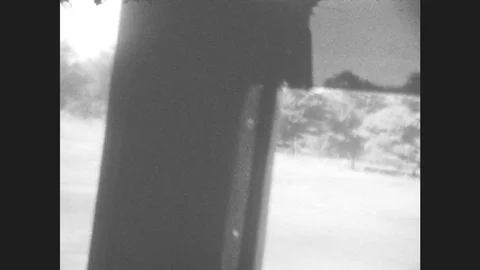 1920s: View out side window of car. Man in passenger seat smiles, makes a goofy Stock Footage 78931626