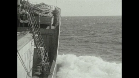1920s: wake of a boat while sailing, a man standing on deck of a boat, barrels Stock Footage 111555302