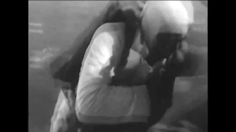 1920sA man skydives, opens seven parachutes during his fall, and receives a kiss Stock Footage 115668159