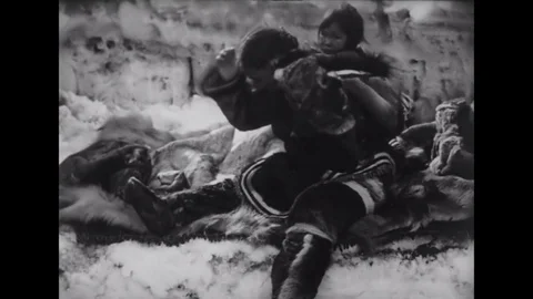 1922 - In this silent documentary, an Inuit woman kisses and cleans her baby. Stock Footage 145400204