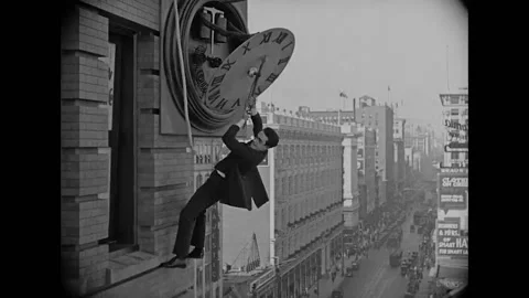 1923 - In this silent comedy, a man (Harold Lloyd) clinging to the hands of a Stock Footage 205512281