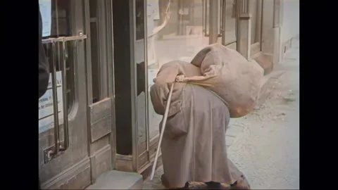 1927 Berlin -  man picks up trash from sidewalk Stock Footage 231505661