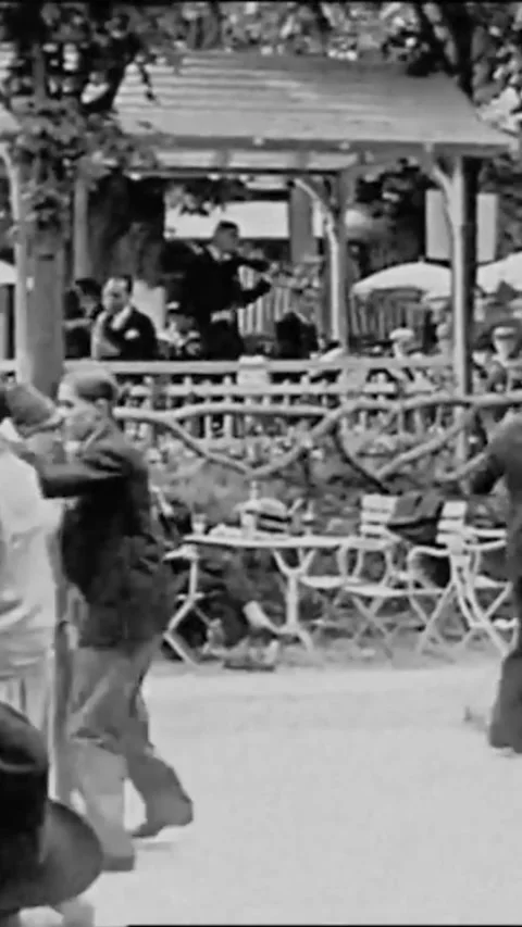1927 - Couples dance in a public park in Paris, France, while friends sit at Stock Footage 287572346