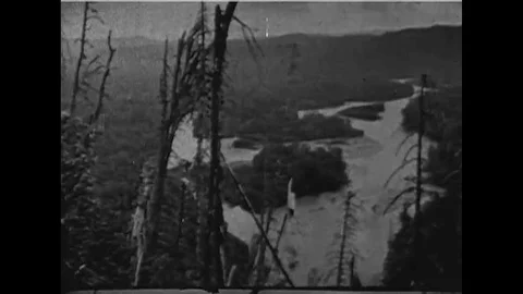 1927 - A wilderness is shown and natives travel in a canoe and camp on the Stock Footage