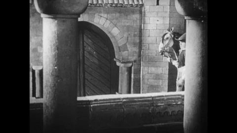 1930s: Animated, men enter castle with horses / Servant talks to king / King and Stock Footage 74940971