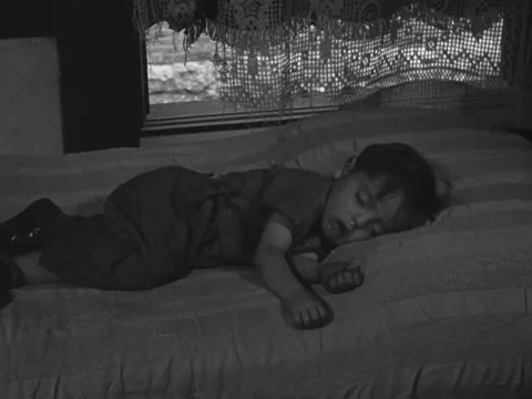 1930s: Boy sleeping on bed Stock Footage 231919948