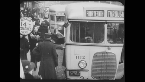 1930s: Bus engine running. People get onto a bus at a stop. Busses in traffic. Stock Footage 158967647