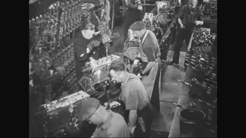 1930s - Car components are worked on as they pass automotive factory workers on Stock Footage 125695162