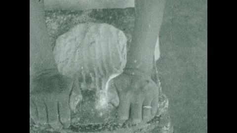 1930s: Close up, hands pick up rolling pin, roll masa on stone. Stock Footage 102696430