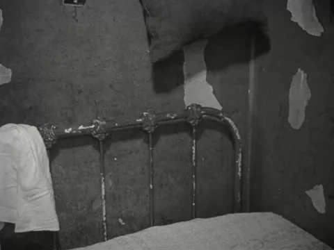 1930s: Empty bed and peeling wallpaper Stock Footage 231920495