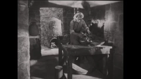 1930s  ENGLAND: A man works in a rustic interior, shaping and smoothing clay Stock Footage 337200996