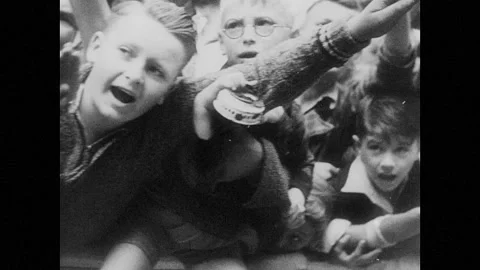 1930s Germany: young boys cheering and saluting as Hitler passes by in parade, Stock Footage
