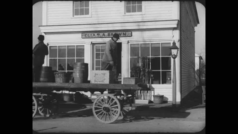 1930s: Horse drawn flatbed wagon comes to a stop in front of a store. Man gets Stock Footage