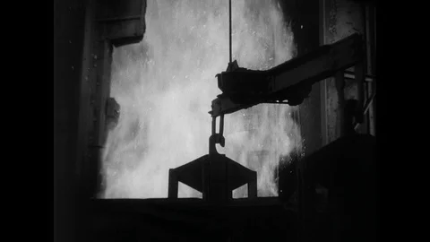 1930s: Large bin is lifted up. Fire burns, man adjusts knobs. Large bin is moved 스톡 동영상 93278624