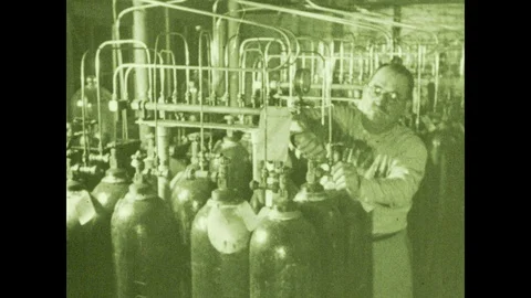 1930s: Man adjusts knobs on tank. Man opens panel, turns knob. Tube rises under 스톡 동영상 104992591
