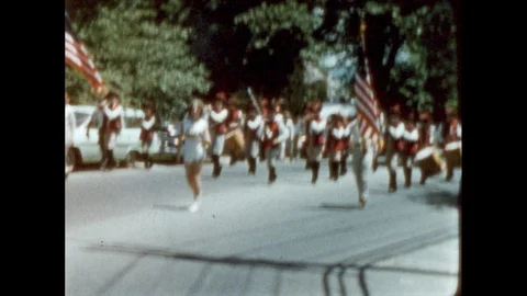 1930s: Marching band marches down street. Antique car drive down street. Parade Stock Footage 112346560