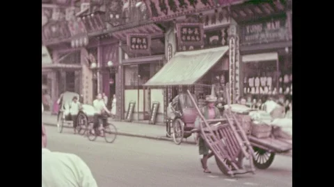 1930s: Men push and pull heavy loads.  Men run down the street with rickshaws.  Stock Footage 87044417