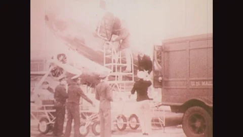 1930s: Men unload parcels from plane. Propeller spins. Airplane taxiing. Stockbeeldmateriaal 77217670