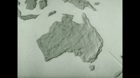 1930s: Stick points to Australia on globe. Model of spider on map of Sydney. Vídeos de archivo 118860550