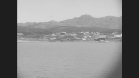1930s: Town Of Skagway, Alaska On The Shore Of A Lake. Snow-Covered Mountains Stock Footage