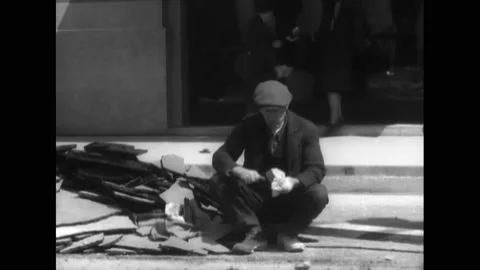 1930s - Two workmen eat lunch on the curb of a street in Paris, France. Stock Footage 157166803