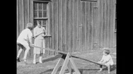 1930S: United States: Children Play On See-Saw. Girl And Boy On See-Saw. Lady Stock Footage