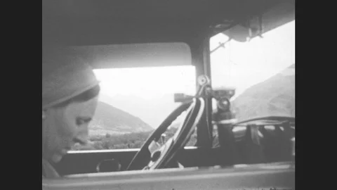 1930s: Woman Sits In Front Seat Of Car And Reads As Girls In Back Plays With Stock Footage