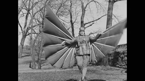 1932 - People attempt to fly by jumping off small ledges with handmade wings. Stock Footage 241606374