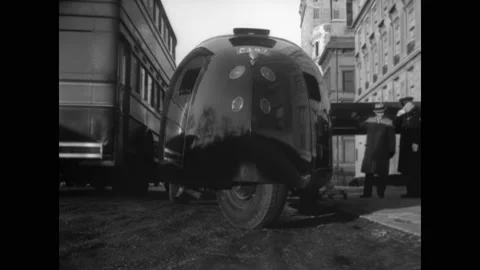 1934 - An experimental three-wheeled car is driven down a city street. Stock Footage 234532632