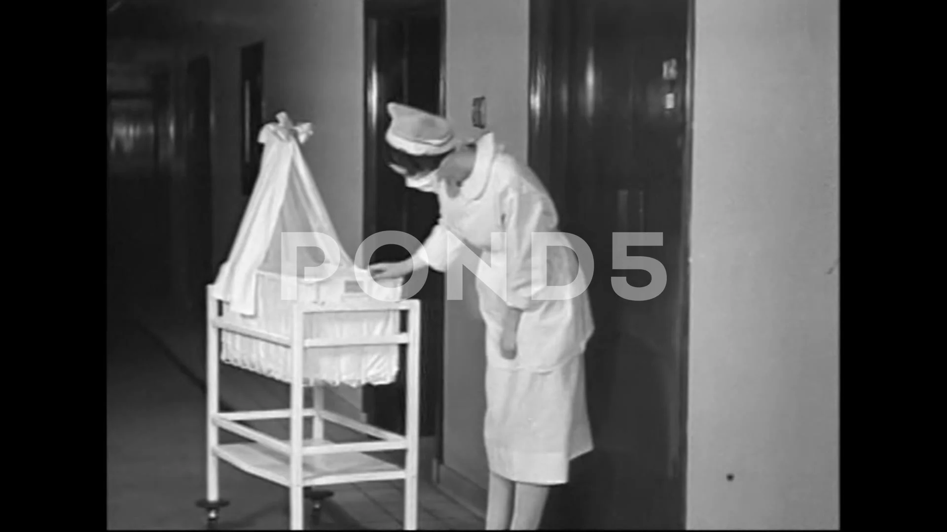 1936 - A nurse returns a baby to its mother in the maternity ward, and  tends to