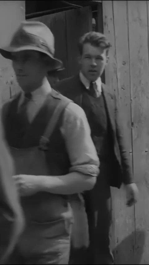 1938 - British workers put donations in a man's cup on their way out of work. Stock Footage 287568337