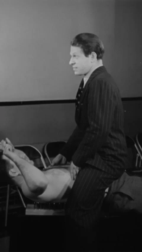1939 - A daredevil lies down on a bed of spikes and has another man sit on top Stock Footage 284130784