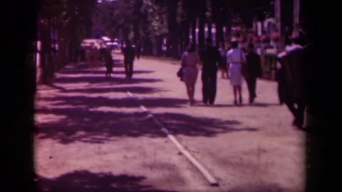 1939: people stroll down a path in a park on a sunny day PARIS FRANCE Stock Footage 70655926