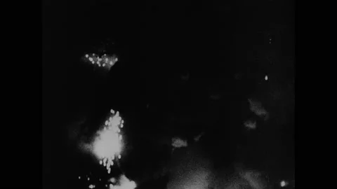 1940s: Aerial shots of bombs exploding at night. Intertitle. Group of freed Video stock 148223878