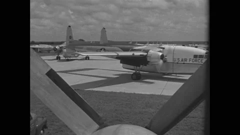 1940s: Air Force cargo planes on tarmac. Soldiers parachute from planes in sky. 스톡 동영상 158448350